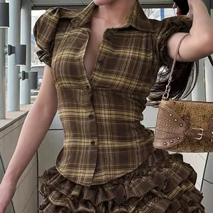 Detailed shot of a vintage brown plaid shirt featuring puff sleeves and buttons