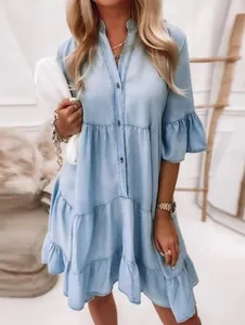 Détail d'une robe midi en jean bleu clair avec manches à volants et boutonnage sur le devant