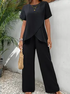 Detailansicht eines schwarzen Plissee-Sets mit asymmetrischem Oberteil und weiter Hose