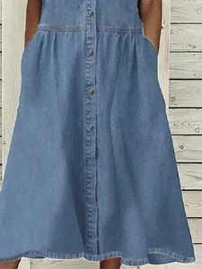 Detail view of casual blue denim dress with functional buttons and side pockets