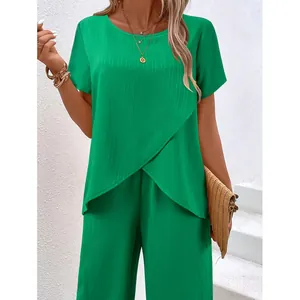 Elegantes grünes zweiteiliges Sommeroutfit mit unregelmäßigem Top und weiter Faltenhose