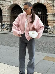 Pink bouclé stand collar jacket worn by model in an outdoor urban street setting.