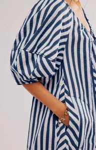 Close-up of blue and white vertical striped romper with puff sleeves and pocket detail