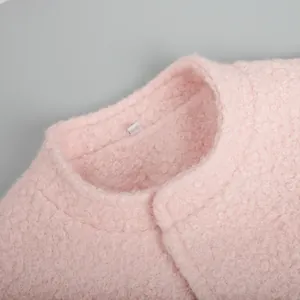 Detail shot of the stand-up collar and soft pink boucle texture on this winter jacket
