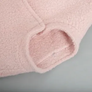 Macro view of the soft pink bouclé fabric texture on a winter jacket stand collar