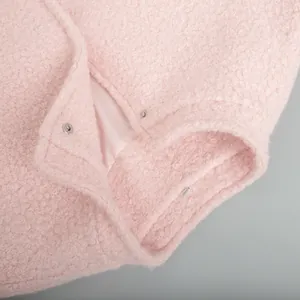 Close-up of pink textured winter jacket with stand collar and snap buttons