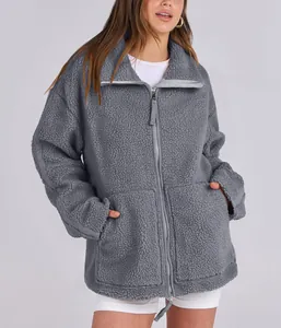 Close-up of a grey oversized teddy fleece jacket with double zipper and plush texture