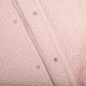 Close-up macro detail of soft pink furry jacket texture and silver metal snap buttons