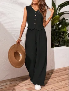 Full-body view of a black linen V-neck vest and wide-leg trousers set with a straw hat