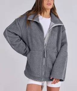 Detailed view of grey oversized teddy jacket featuring warm plush texture and dual zipper.