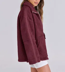 Side profile of a cozy burgundy oversized fleece teddy jacket with zipper details