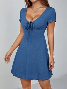 Gros plan sur une robe bleue à col en V avec détail de nœud à l'avant et texture côtelée