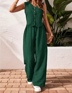 Model wearing a dark green linen vest and wide-leg pants set in a sunny outdoor setting
