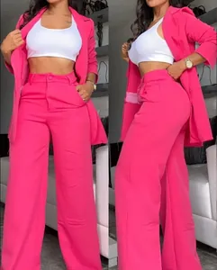 Detail of vibrant pink two-piece suit with slit sleeves and wide-leg trousers for women.