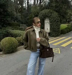 Vista lifestyle di un giubbotto bomber kaki con maniche a pipistrello in un giardino