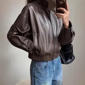 Detailed view of a vintage brown PU leather biker jacket for women styled with jeans