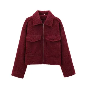 Nahaufnahme der weinroten Bouclé-Jacke mit Stoffstruktur und silbernem Reißverschluss.