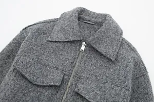 Nahaufnahme einer grauen Kurzjacke aus strukturiertem Tweed mit Metallreißverschluss