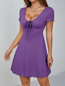 Détail de la robe moulante violette à col en V avec devant froncé et style français.
