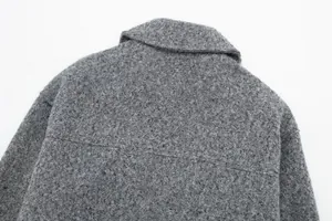 Detailansicht des grauen Bouclé-Tweed-Stoffes und Kragens einer Damenjacke aus nächster Nähe