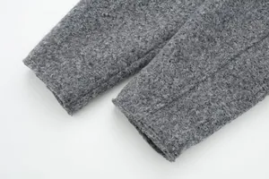 Detaillierte Nahaufnahme der dicken Tweed-Stofftextur an einem grauen Jackenärmelaufschlag