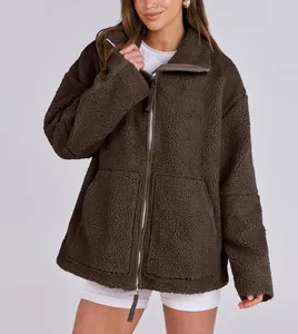 Detail of oversized dark brown teddy jacket with double zipper and fleece texture