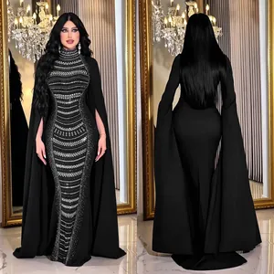 Elegante vestido de noche negro con pedrería brillante y mangas largas tipo capa.