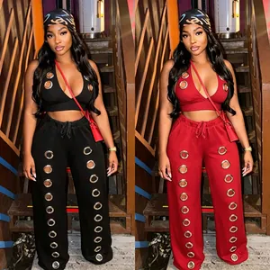 Fashionable women's two-piece set featuring oversized metal eyelet details on top and pants