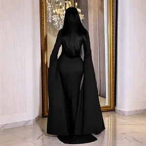 Vista trasera de un elegante vestido de noche negro largo hasta el suelo con mangas de capa