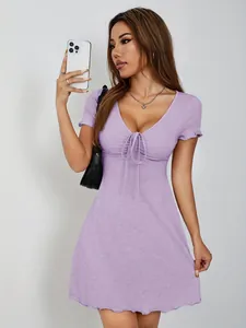 Modèle portant une robe lavande à col en V avec détail noué et ourlet à volants