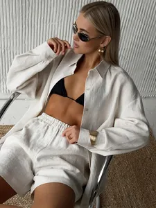Detailed view of elegant women's beige linen-style loose shirt and shorts set
