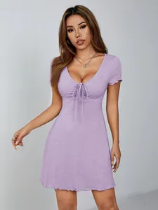 Vue détaillée d'une mini-robe lilas à col en V avec un nœud et des bords à volants.