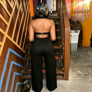 Trendy back view of black two-piece clothing set with halter top and wide-leg pants