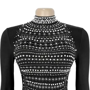 Primer plano detallado de vestido negro con adornos de perlas y diamantes de imitación