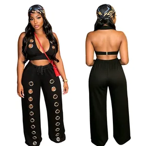 Close-up detail of a black two-piece outfit featuring large silver metal grommet accents.