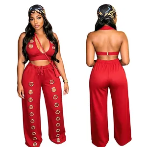 Red two-piece set featuring halter crop top and wide leg pants with gold grommet details