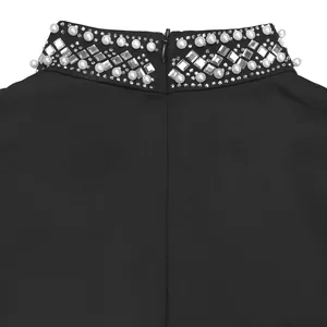 Primer plano del cuello de un vestido negro elegante con perlas y pedrería brillante