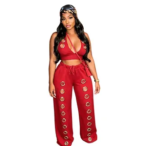 Detailed view of red two-piece set featuring oversized silver eyelets and wide leg pants.