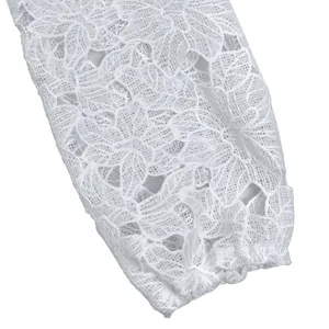 Detailed macro view showing the intricate white floral lace pattern on mesh dress sleeve
