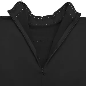 Primer plano de vestido de noche negro con cuello de pedrería plateada y cremallera