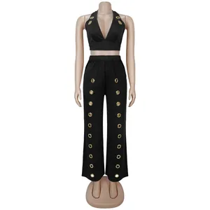 Front view of black halter neck top and wide-leg trousers set with gold grommet details