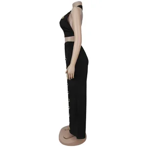 Side view of black two-piece set with halter top and wide-leg pants with metal eyelets