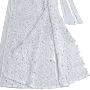 Detail shot of intricate white floral lace pattern on a sexy evening slit dress garment