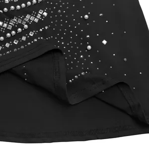 Vista detallada de elegantes adornos de pedrería y perlas de imitación en un vestido negro.