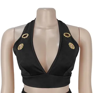 Close-up detail view of stylish black halter crop top featuring decorative gold grommet eyelets