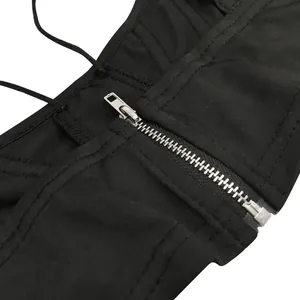 Detail close-up view of a silver metal zipper on a black mesh two-piece set garment.