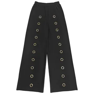 Detailed view of black wide-leg pants featuring vertical gold metal grommet accents