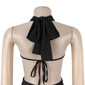 Close-up view of a sexy backless black jumpsuit detail showing large halter neck bow tie