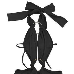 Detailed view of sexy black halter neck jumpsuit featuring a bow and golden rings