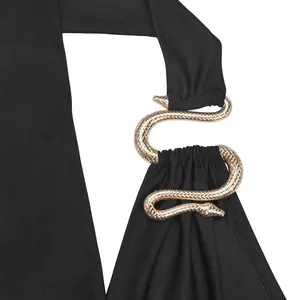 Close-up detail of a textured golden snake metal buckle on a black halter bodycon dress